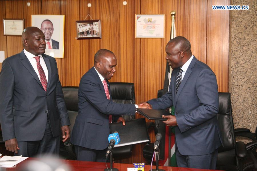 Willy Bett (R), Kenyan Cabinet Secretary in the Ministry of Agriculture, Livestock and Fisheries and Gabriel Rugalema (C), Food and Agriculture Organization (FAO) representative in Kenya, exchange signed agreement documents in Nairobi, capital of Kenya, March 15, 2017. 