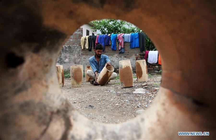 Craftsmen make traditional drums at slum area in Indiancontrolled Kashmir Xinhua English