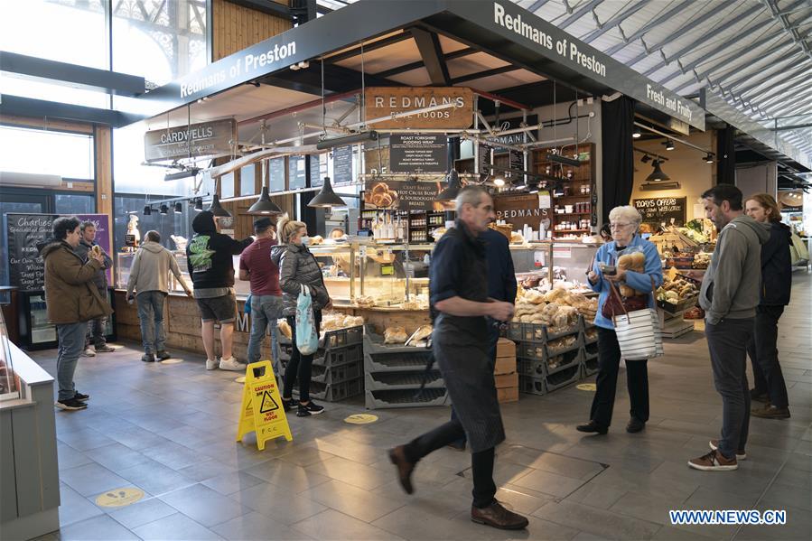 people shop at reopened market in bury, britain