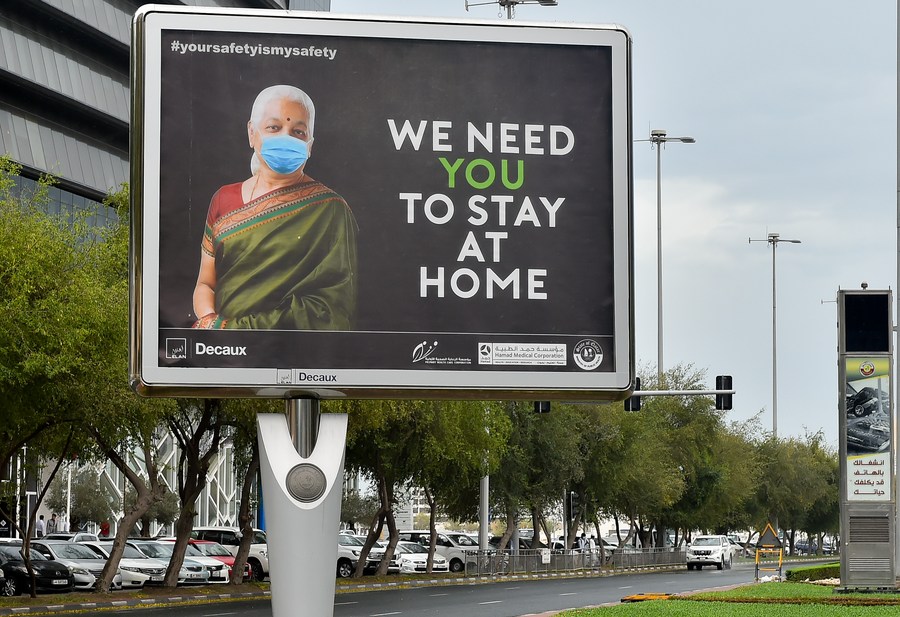 Covid 19 billboard with an old Indian woman wearing mask urging everyone to stay at home