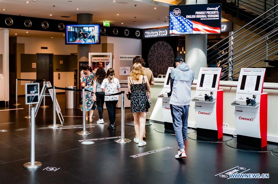 People walk into reopened movie theater in Berlin, Germany Xinhua