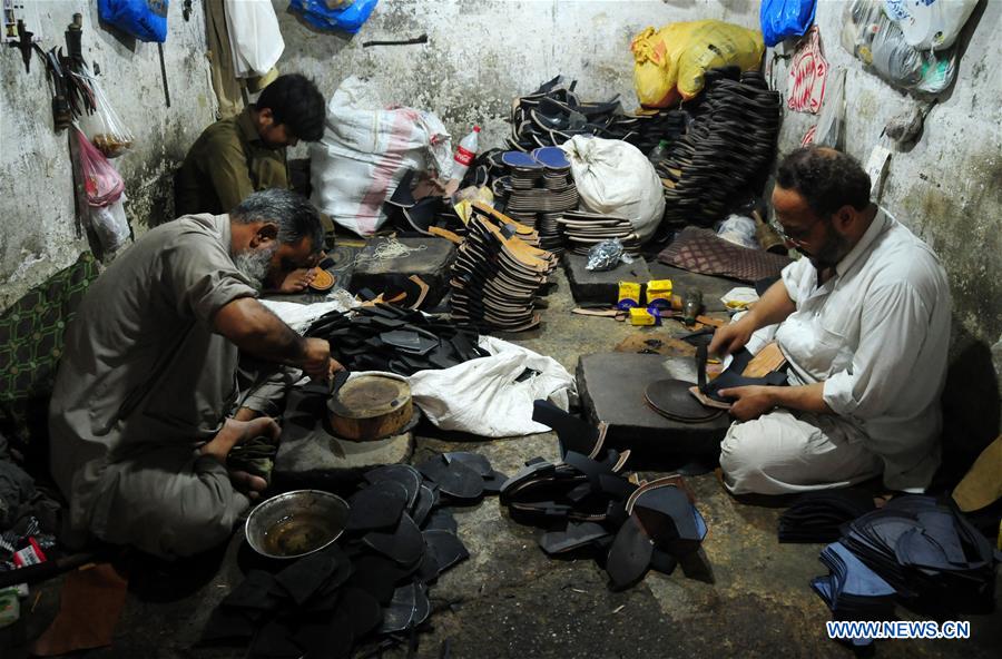 Workers make traditional shoes at shop in Pakistan's Peshawar Xinhua