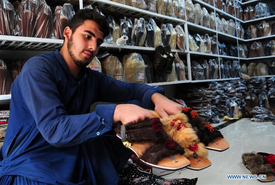 Workers make traditional shoes at shop in Pakistan's Peshawar Xinhua