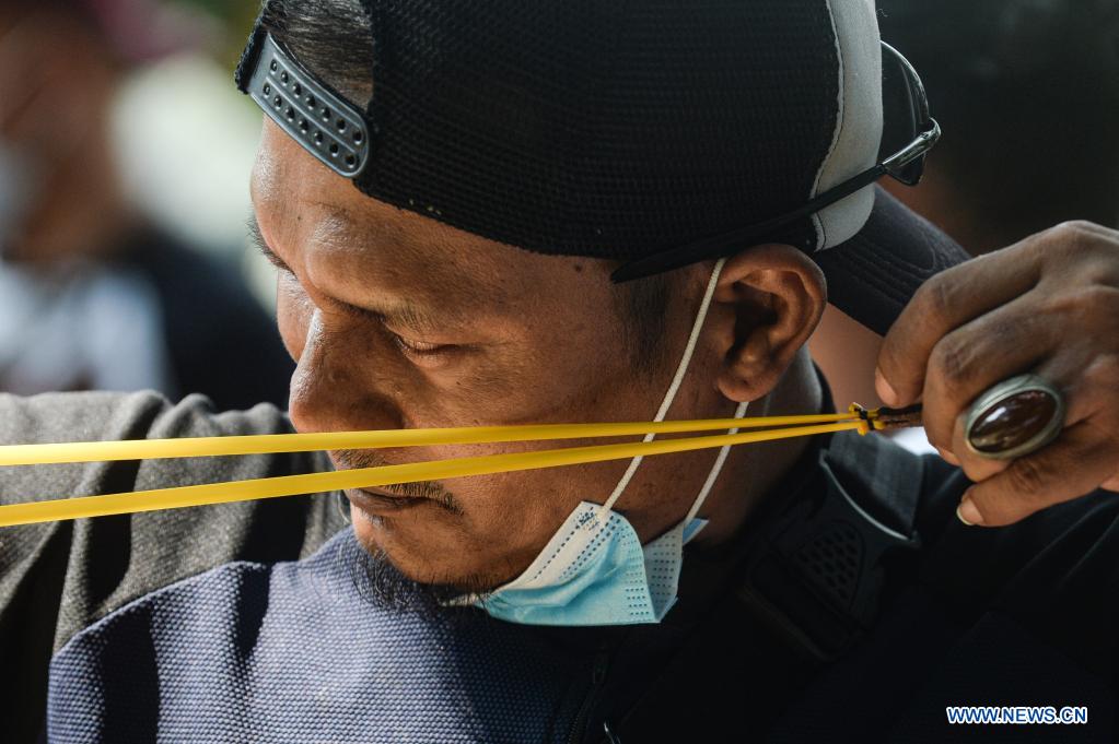 People participate in traditional slingshot regional competition in