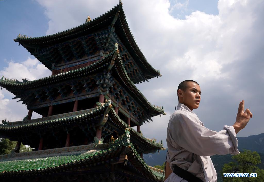 Shaolin monks practice martial arts at Pagoda Forest of Shaolin Temple in Henan Xinhua