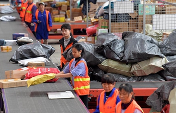 Workers sort parcels at express delivery company in China's Jiangxi