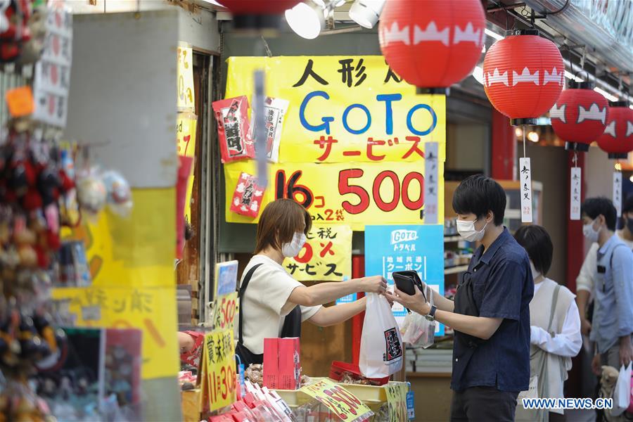 people wearing face masks buy local specialty at asakusa, in