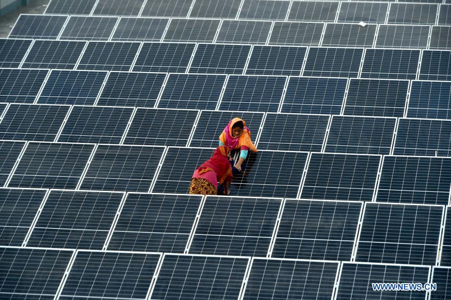 Supervisors monitor installation process of solar panels on factory