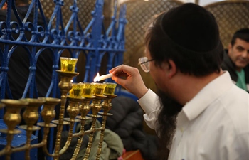 Jewish men light menorah during Hanukkah in Meron, Israel