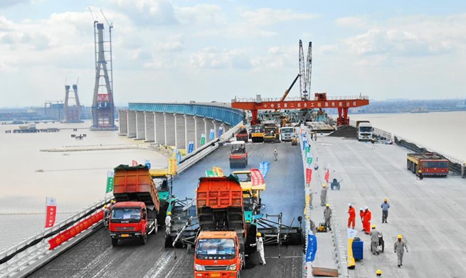 Workers pave asphalt on surface of Shanghai-Nantong Railway Bridge in China's Jiangsu