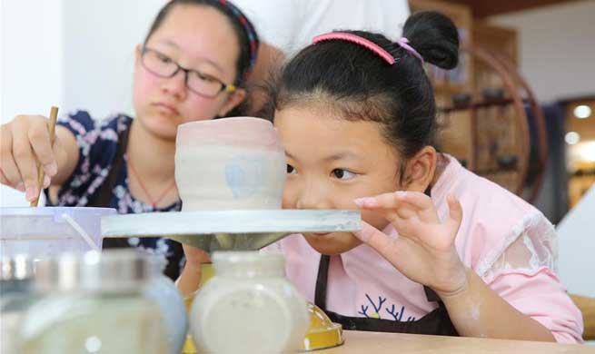 Children learn to make ceramics during National Day holiday in China's Jiangsu