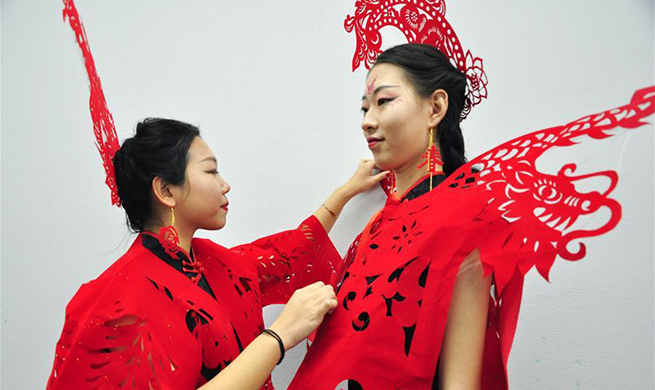 Pic story: craftswoman makes papercutting works of cheongsam to greet Spring Festival