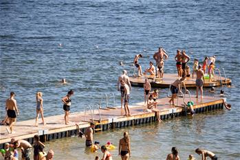 People cool off at lake beach in Stockholm, Sweden