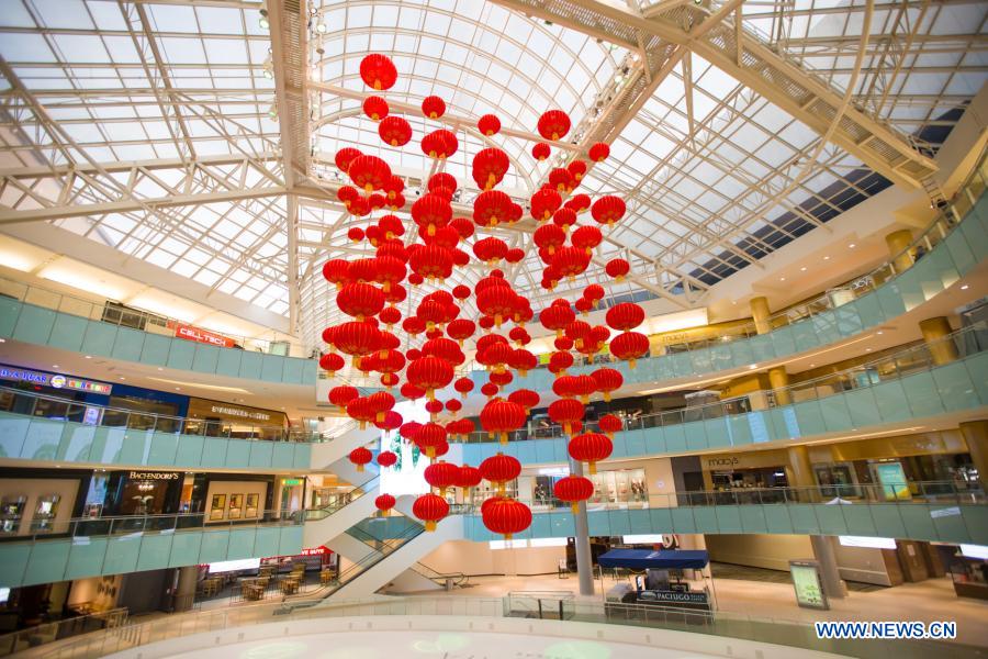 Staff members install red lanterns in Galleria Dallas shopping