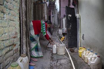 Indian people get water from tap in New Delhi