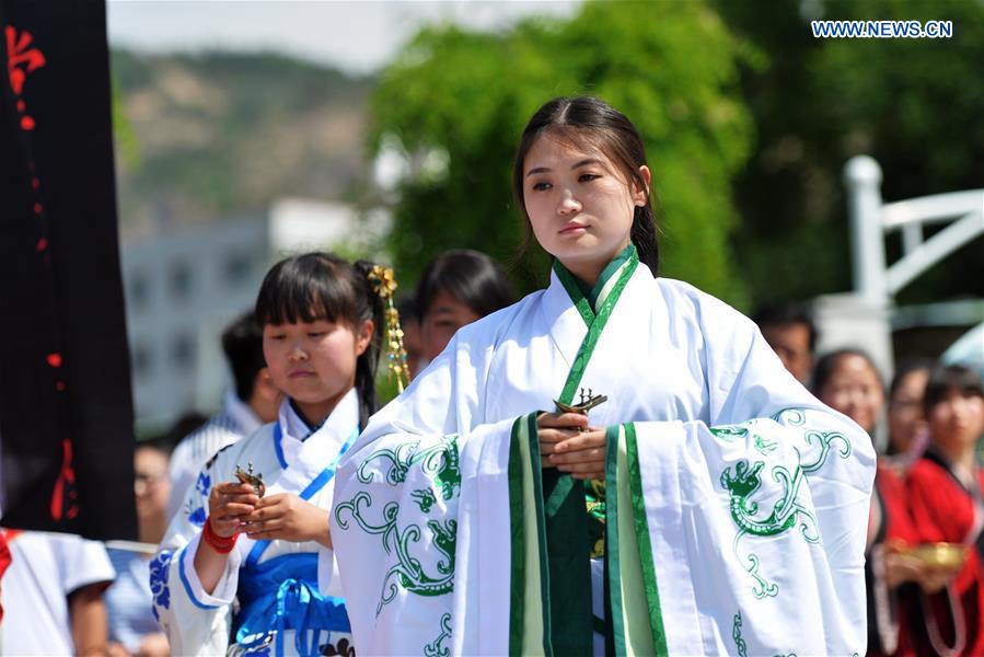 People in Han dresses perform feast ritual during a sacrificial ceremony for Qu Yuan, a patriotic poet who drowned himself before his state fell to the invasion of the enemy during the Warring States Period (475-221 BC), in Lanzhou, capital of northwest China's Gansu Province, June 9, 2016. People in Han dresses perform feast ritual during a sacrificial ceremony for Qu Yuan, a patriotic poet who drowned himself before his state fell to the invasion of the enemy during the Warring States Period (475-221 BC), in Lanzhou, capital of northwest China's Gansu Province, June 9, 2016.