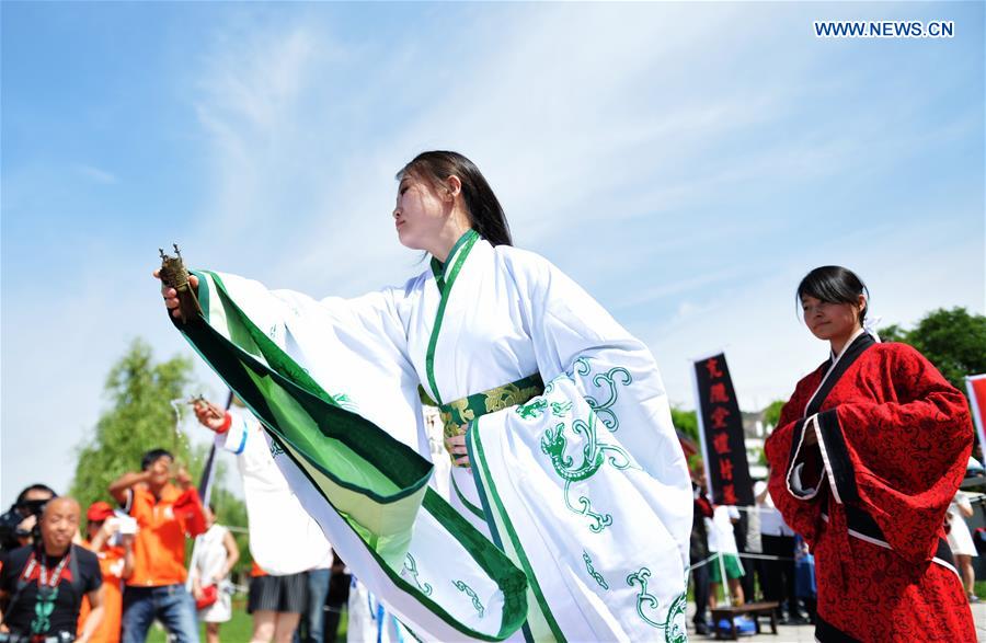 People in Han dresses perform feast ritual during a sacrificial ceremony for Qu Yuan, a patriotic poet who drowned himself before his state fell to the invasion of the enemy during the Warring States Period (475-221 BC), in Lanzhou, capital of northwest China's Gansu Province, June 9, 2016. People in Han dresses perform feast ritual during a sacrificial ceremony for Qu Yuan, a patriotic poet who drowned himself before his state fell to the invasion of the enemy during the Warring States Period (475-221 BC), in Lanzhou, capital of northwest China's Gansu Province, June 9, 2016.