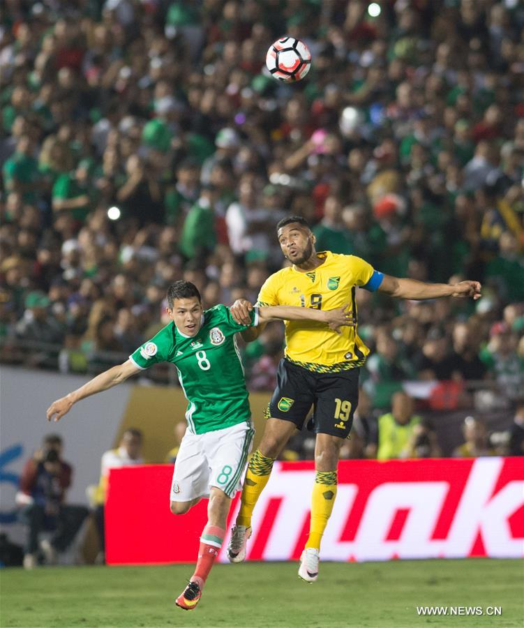 Jamaica's Clayton Donaldson (Top) is tackled during the Copa America Centenario tournament Group C football match between Mexico and Jamaica in Pasadena, California, the United States, on June 9, 2016.