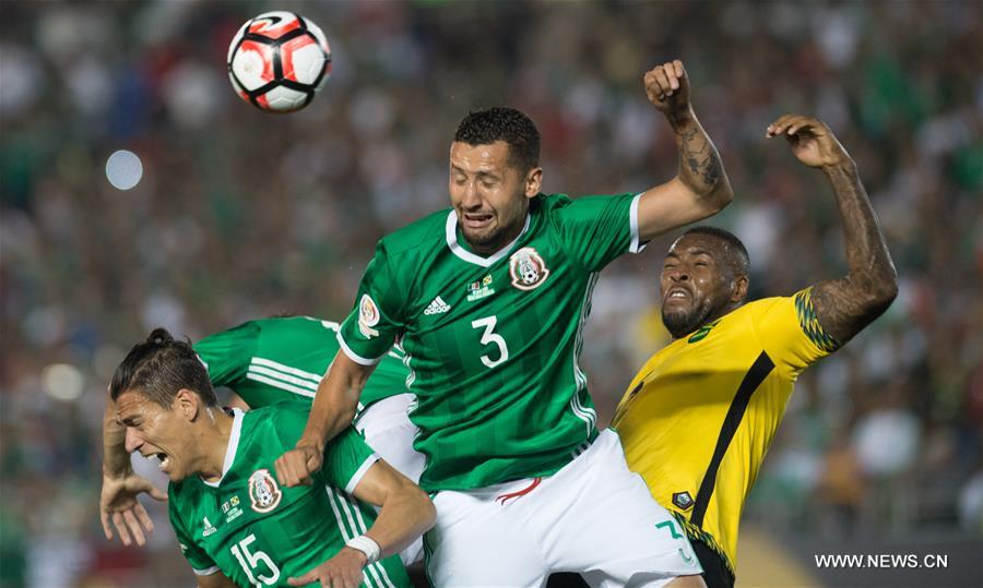 Jamaica's Clayton Donaldson (Top) is tackled during the Copa America Centenario tournament Group C football match between Mexico and Jamaica in Pasadena, California, the United States, on June 9, 2016.