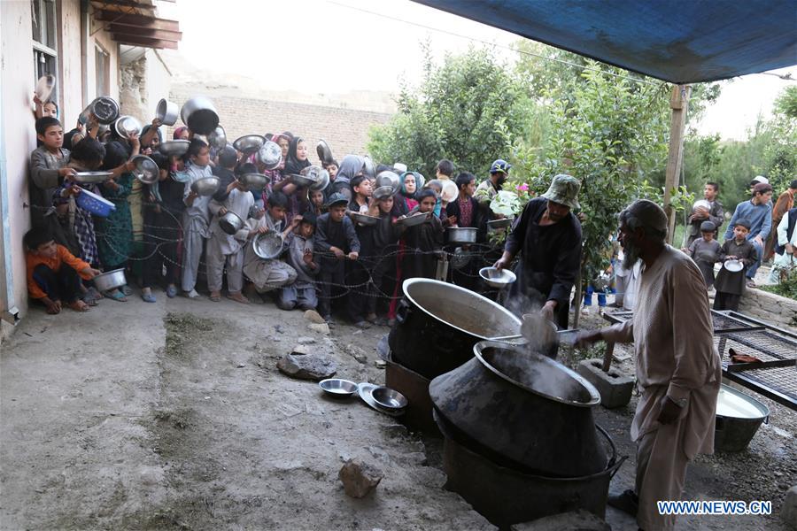An Afghan man distributes food to children during the holy month of Ramadan in Ghazni province, Afghanistan, June 10, 2016. An Afghan man distributes food to children during the holy month of Ramadan in Ghazni province, Afghanistan, June 10, 2016.