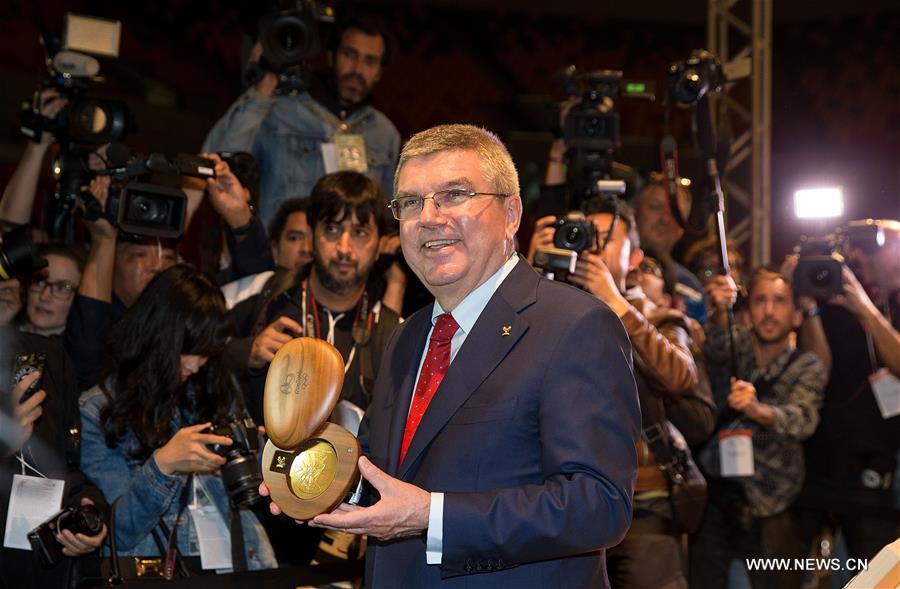 President of the International Olympic Committee (IOC) Thomas Bach delivers a speech as the slogan of the Rio 2016 'A new world' is shown on the screen at the unveiling ceremony held at the Future Arena in the Barra Olympic Park in Rio de Janeiro, Brazil, on June 14, 2016. President of the International Olympic Committee (IOC) Thomas Bach delivers a speech as the slogan of the Rio 2016 'A new world' is shown on the screen at the unveiling ceremony held at the Future Arena in the Barra Olympic Park in Rio de Janeiro, Brazil, on June 14, 2016.