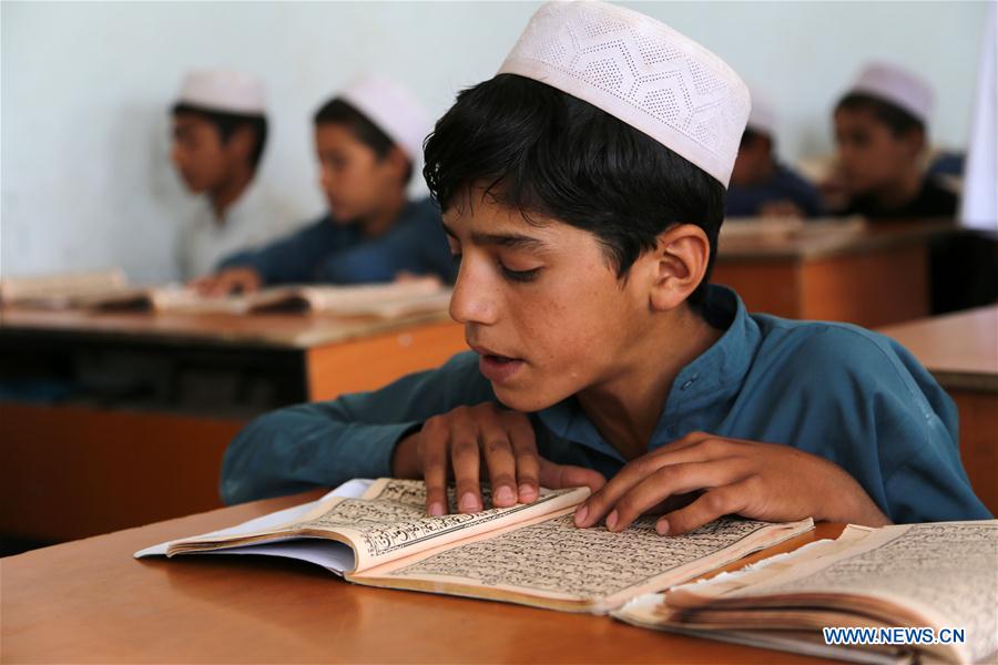 An Afghan religious man teaches boys to read Muslim holy book of Quran in Herat province, Afghanistan, June 14, 2016. 