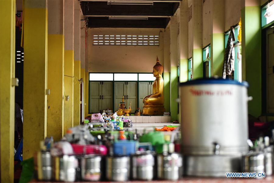 A teacher (1st L) revises homework for students at a school dedicated for the children of Myanmar migrant workers set inside Wat Tepnorrarat in Mahachai of Samut Sakhon Province, central Thailand, June 16, 2016. 