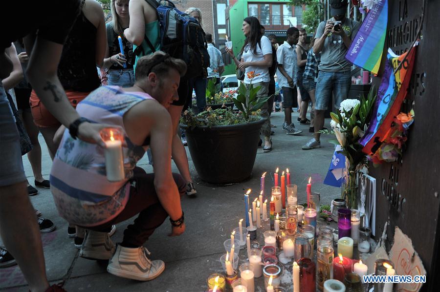 People hold candles and a torch to pay tribute to Orlando nightclub shooting victims, in downtown Montreal, Canada, on June 16, 2016. People hold candles and a torch to pay tribute to Orlando nightclub shooting victims, in downtown Montreal, Canada, on June 16, 2016.