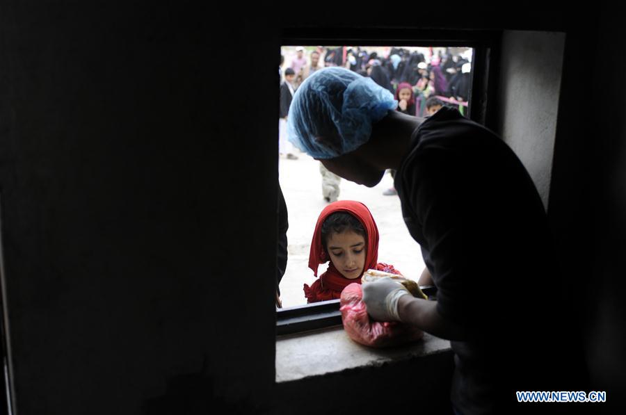  Yemeni girls wait to receive free dinner meals at a charity center in Sanaa, Yemen, on June 24, 2016.