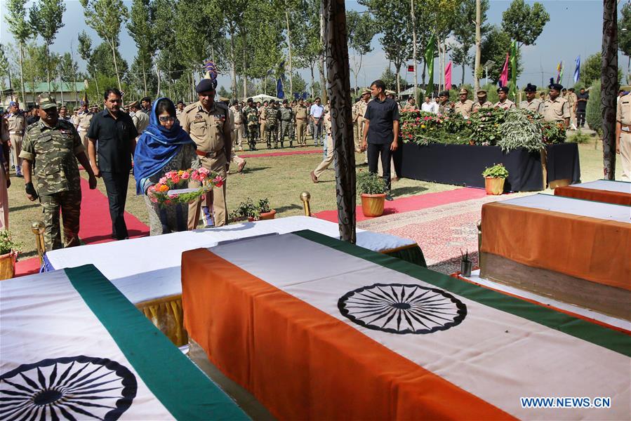 A senior Indian police official salutes to the slain Indian paramilitary troopers during a wreath laying ceremony in Humhama, on the outskirts of Srinagar, summer capital of Indian-controlled Kashmir, June 26, 2016.
