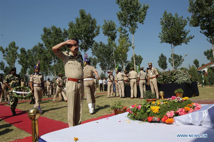 A senior Indian police official salutes to the slain Indian paramilitary troopers during a wreath laying ceremony in Humhama, on the outskirts of Srinagar, summer capital of Indian-controlled Kashmir, June 26, 2016.
