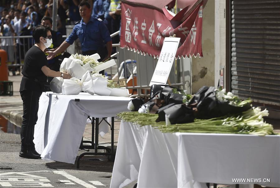 A memorial service is held at the fire site of an industrial building in Hong Kong's East Kowloon to pay tribute to Thomas Cheung, a 30-year-old senior station officer who died while battling the fire, in south China's Hong Kong, June 27, 2016. 