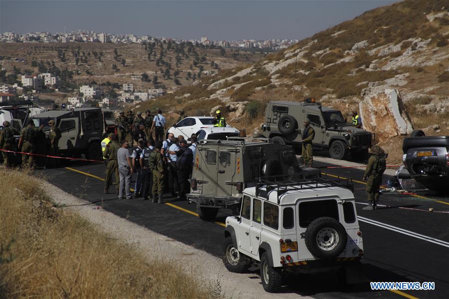 Israeli security forces gather at the scene where an Israeli died and three of his relatives were wounded after a suspected Palestinian gunman opened fire at their car on July 1, 2016 on route 60, near al-Fawar refugee camp, south of Hebron in the West Bank.