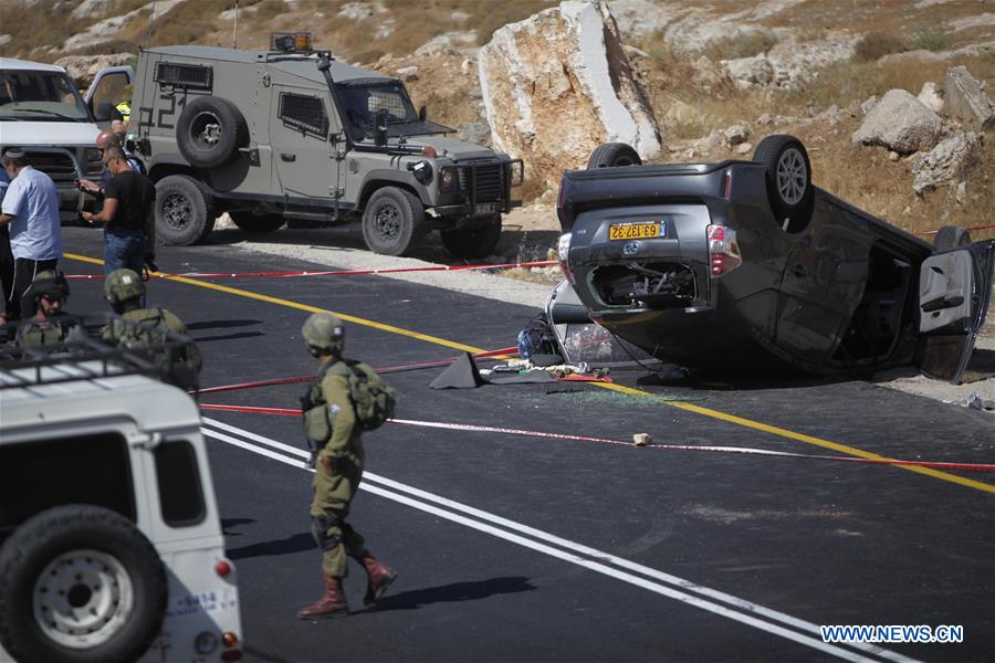 Israeli security forces gather at the scene where an Israeli died and three of his relatives were wounded after a suspected Palestinian gunman opened fire at their car on July 1, 2016 on route 60, near al-Fawar refugee camp, south of Hebron in the West Bank.