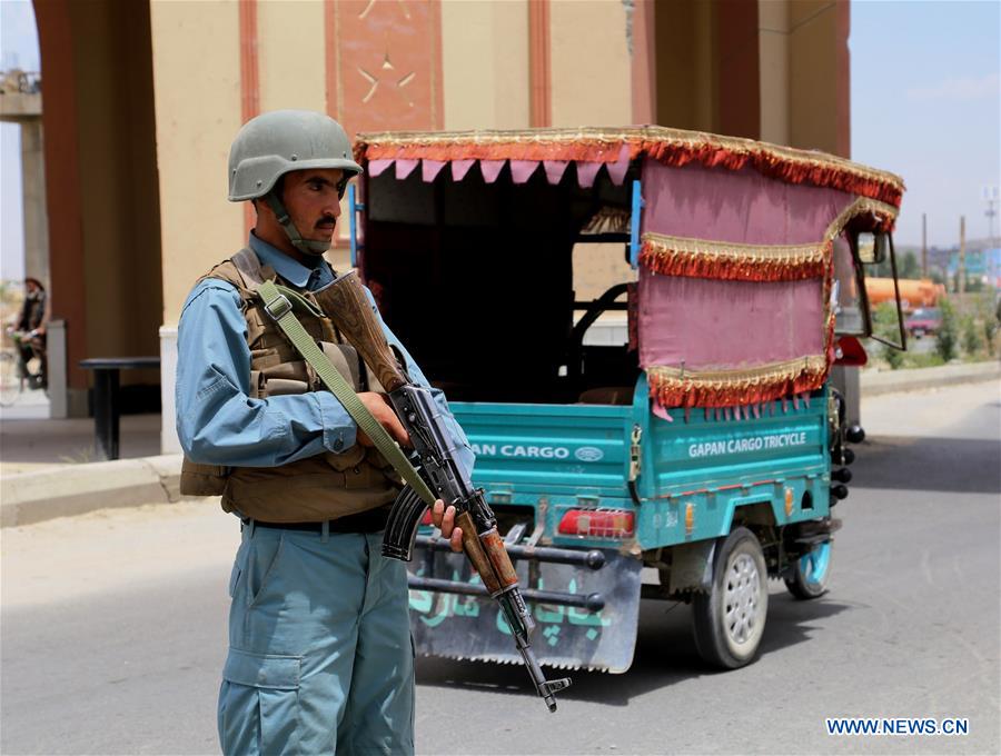 A policeman searches a passenger at a police checkpoint in Ghazni province, eastern Afghanistan, July 4, 2016. 