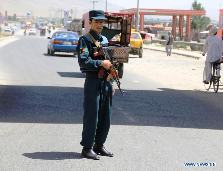 A policeman searches a passenger at a police checkpoint in Ghazni province, eastern Afghanistan, July 4, 2016. 