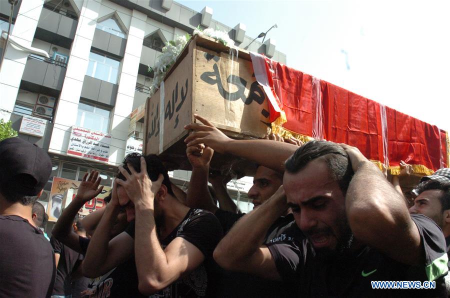 People carry a coffin as they mourn for the victims killed in Sunday's car bombing attacks in Karrada-Dakhil district in southern Baghdad, Iraq, on July 5, 2016.