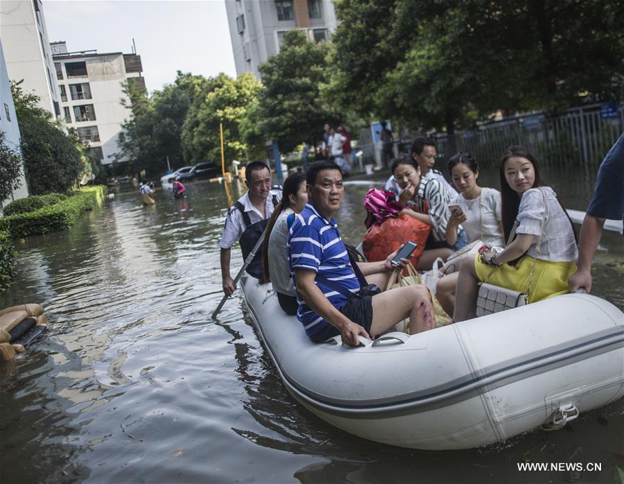 Rescuers push a car out of a flooded street in waterlogged Nanhu Lake area in Wuhan, capital of central China's Hubei Province, July 7, 2016.