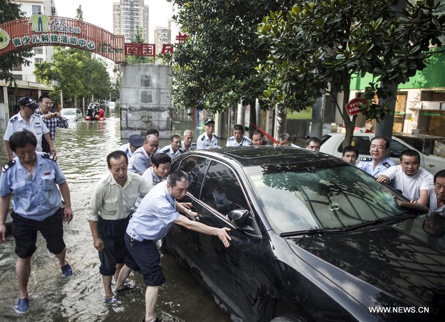 Rescuers push a car out of a flooded street in waterlogged Nanhu Lake area in Wuhan, capital of central China's Hubei Province, July 7, 2016. Rescuers push a car out of a flooded street in waterlogged Nanhu Lake area in Wuhan, capital of central China's Hubei Province, July 7, 2016.