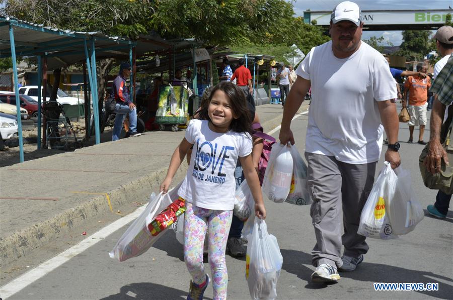 Photo provided by Diario La Opinion shows Venezuelan citizens crossing the border between Venezuela and Colombia to buy food and other products in San Jose de Cucuta, Colombia, on July 10, 2016.