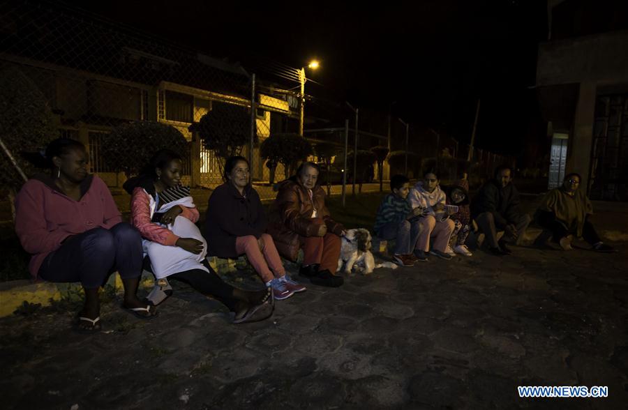 People stay on a street after earthquakes in Quito, Ecuador, on July 10, 2016. 
