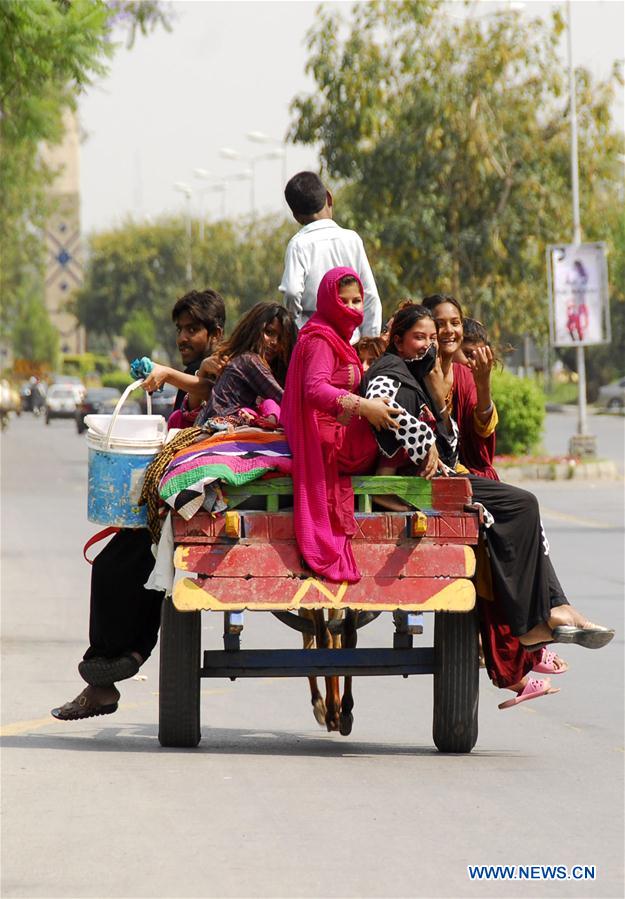 Girls ride on a donkey-cart on World Population Day in Islamabad, capital of Pakistan on July 11, 2016.