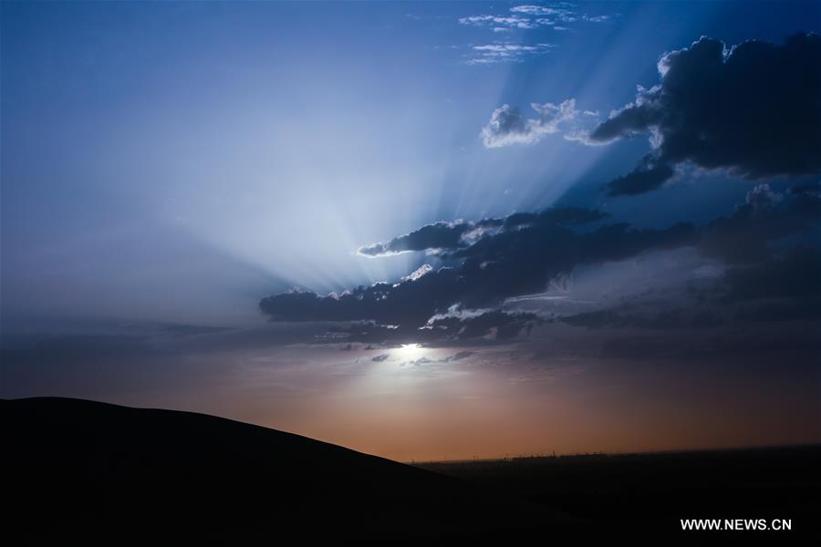 The scene of sunset is seen at the Singing Sand Dune in Dunhuang, northwest China's Gansu Province, July 11, 2016.