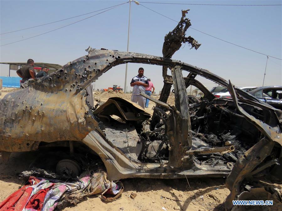A man inspects a car damaged in an explosion at a crowded checkpoint in Husseiniyah neighborhood in Baghdad, capital of Iraq, on July 13, 2016.