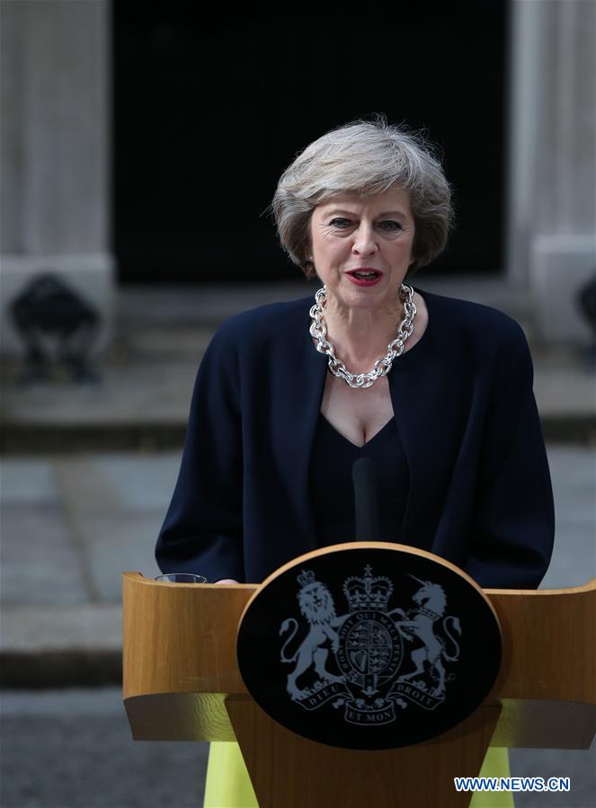 Britain's new Prime Minister Theresa May(L) and her husband pose for photos in front of 10 Downing Street in London, Britain on July 13, 2016.