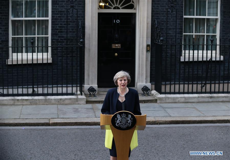 Britain's new Prime Minister Theresa May(L) and her husband pose for photos in front of 10 Downing Street in London, Britain on July 13, 2016.