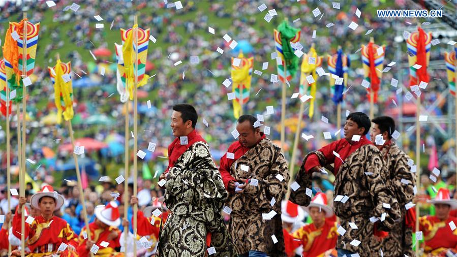 People throw Longda, white papers printed with horses, for praying at the opening ceremony of Shambhala Tourism Festival in Gannan, northwest China's Gansu Province, July 17, 2016. 