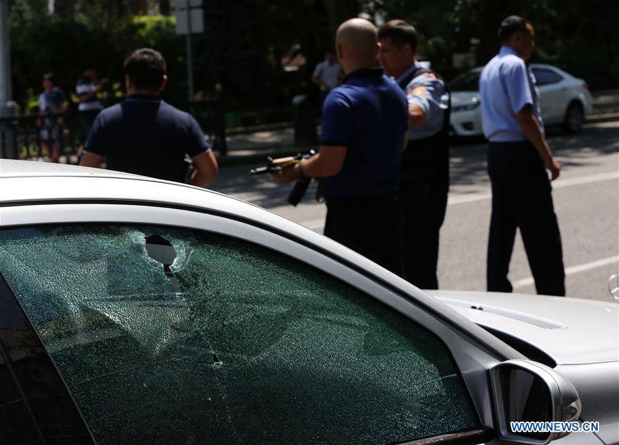 Police officers detain a man at a scene of shooting on the street in Almaty, Kazakhstan, July 18, 2016.
