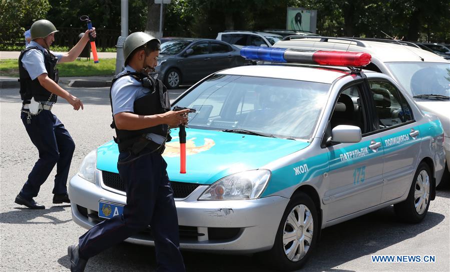 Police officers detain a man at a scene of shooting on the street in Almaty, Kazakhstan, July 18, 2016.
