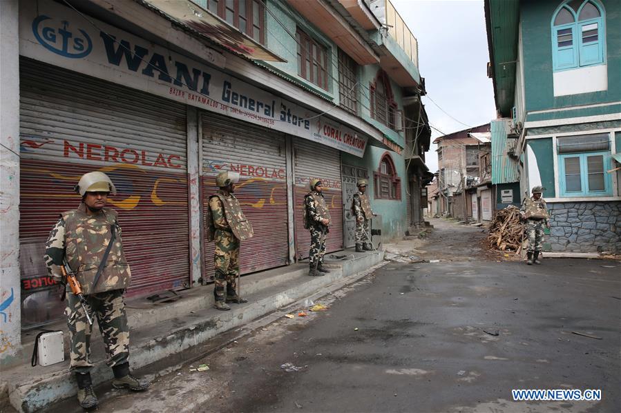 A Kashmiri woman and her child walk past Indian paramilitary troopers during the curfew in Srinagar, summer capital of Indian-controlled Kashmir, on July 18, 2016. A Kashmiri woman and her child walk past Indian paramilitary troopers during the curfew in Srinagar, summer capital of Indian-controlled Kashmir, on July 18, 2016.